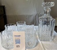 Front view of decanter and five glasses (one glass partly out of frame) showing pattern and scale