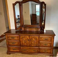 Front view showing dresser, eight drawers, central cabinet, tri-fold mirror