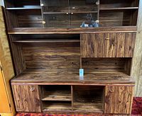 Front view showing entire entertainment unit with shelves, compartments and brass hardware