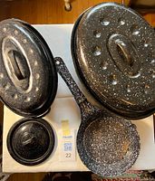 Top view of both roasters with lids, frying pan, spare lid