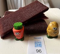 Front view of both novelty brushes and folded Scotch-Brite pads