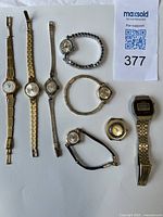 Front view of eight watches showing faces, bracelets and watch face