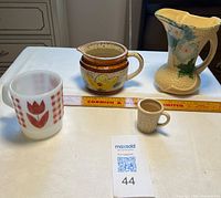 All four pottery items arranged with ruler for scale