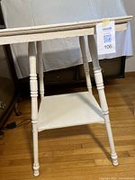 Side view of the two-tier square table showing turned legs and lower shelf