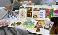 Group of displayed vintage greeting cards with floral, holiday, and children themes