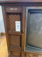 Close-up of left front cabinet corner showing Zenith logo badge and lattice speaker grille