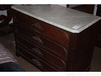 Front view of dresser showing three carved drawers and white marble top