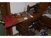Full view of cabinet top with sewing machine, attachments box and textiles