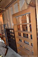 Three shelving units arranged in basement; wooden and metal shelves visible