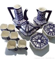 Full tea set with teapot, pitcher, sugar bowl, cups, and saucers seen from above, showing the blue and white ornate pattern.
