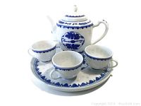 Full view of the blue and white porcelain tea set showing teapot, tray, and three teacups in traditional Chinese floral pattern design.