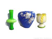 Lot of three vintage decorative vases side by side showing green glass, blue floral ceramic, and yellow cabbage rose compote forms.
