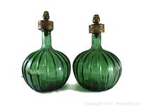 Front view of both green glass decanters labeled 'Bourbon' and 'Vodka'.
