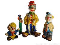 Four vintage clown figurines displayed against white background: small clown with yellow hat, a tall clown in yellow jacket, small green clown cane, and medium sized clown with blue pants and tan jacket.