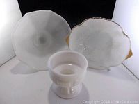 Three milk glass bowls shown together highlighting varying shapes and sizes, one has scalloped edge and another has gold trim.