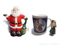 Santa teapot shaped as Santa Claus figure holding sack and spout hand extended. Christmas Traditions collectible mug with vintage Santa image. Small Santa ornament holding tree.