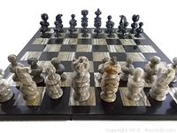 Marble chess set showing full board and set up with all pieces in starting positions. Light and dark marble colors used for squares and pieces. Close detail of the burgundy and cream colored pieces.