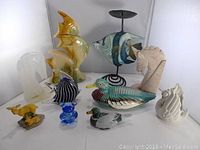 Full overview of the 10 animal figurines including fish, birds, a horse head, deer, and glass figures.