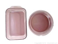 Top view of cranberry Pyrex rectangular casserole dish beside round pie dish, showing overall shape and color