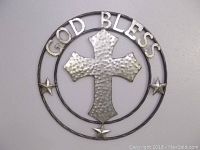Front view of round metal wall decor with hammered cross and the words 'GOD BLESS' around the outer ring along with three stars.
