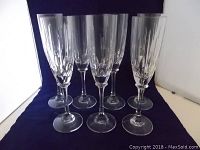 Set of seven vintage lead crystal champagne flutes arranged in a cluster, showing overall shape and faceted cut design.
