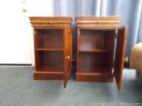 Photo showing the interior of the cabinet portion of both nightstands with the doors open, highlighting storage space consisting of a single shelf inside each cabinet.