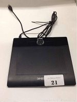 Black Wacom Bamboo drawing tablet with USB cable on white surface, showing round touch ring and shortcut buttons.