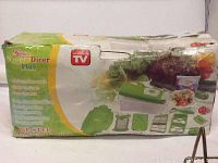 Boxed Genius Nicer Dicer Plus food chopper with some visible wear on packaging.