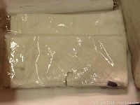 Four white mop pads for Swiffer, folded and sealed in clear plastic packaging.