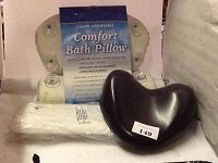 Three assorted bath pillows shown together including a 2-panel adjustable comfort bath pillow with suction cups, a dark brown contoured pillow, and a white rolled pillow.