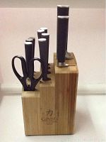 Front view of the bamboo block holding the knives and kitchen scissors, showing the Ginsu Chikara logo.