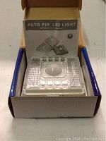Photo of 8 LED Auto PIR LED Light in original packaging with instruction booklet visible.