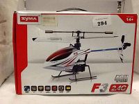Box showing Syma F3 radio control helicopter with 4 channel and 2.4 GHz frequency features, designed for ages 14 and up.