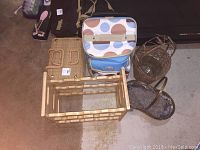 Overview of picnic cooler, wooden wine rack, two wicker baskets, and wine glass holder on a floor.