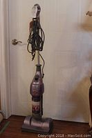 Full upright view of the lavender Shark Vac Steam vacuum with the power cord wrapped around the handles.