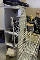 Wire metal shelving units shown, including one unit with multiple shelves and another wire rack with basket.