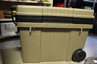 Full side view of the beige and black plastic tool box on wheels showing capacity and wheels.