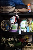 Shelves containing various lawn care products, tarps, folded awnings and containers.