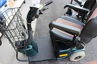 Side view of scooter showing foot deck, seat, armrests and rear wheels