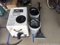 Servicemaster carpet cleaner machine with two buckets and floor tool beside it on floor.