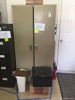 Closed metal storage cabinet with beige color and handle locks.