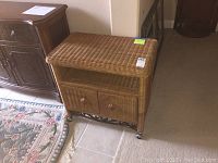 Wicker cabinet showing front and left side with two doors, one open shelf, and caster wheels.