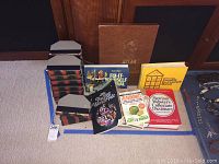 Photo showing the full collection of assorted books including the leather-bound Charles Dickens Pickwick Papers 7-volume set, Atlas, Fix-It Yourself Manual, Complete Do-It-Yourself Manual, and Merriam Webster's Dictionary
