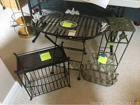 Photo showing all four metal items including oval metal table, black magazine rack, green plant stand, and metal basket.