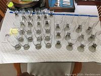 Full spread of 38 assembled Rosenthal glasses on a white cloth with visible different sizes and conical dark bases