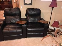 Front view of black leather recliners showing two detachable wood grain trays on armrests