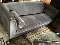 Full front view of sofa showing shape, cushions and bolster pillows