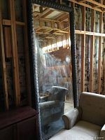 Full-length view leaning against unfinished wall alongside furniture showing height and proportions