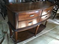 Front angled view of wooden buffet showing curved drawer fronts and metal handles.