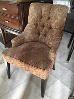 Front angled view of slipper chair showing upholstery pattern and dark wooden legs